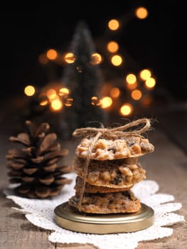 Tasty organic oat cookies on a rustic wooden table with Christmas lights bokeh