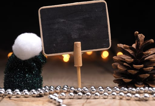 Blank chalkboard with Christmas decoration and Christmas lights bokeh on a wooden table