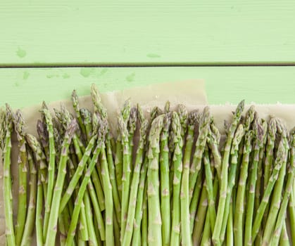 Gruener asparagus on rustic background made of wood