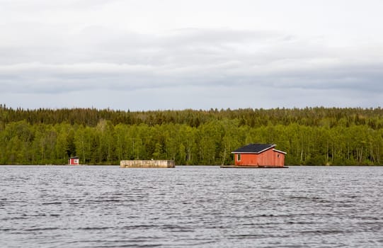 House in the middle of River in Umea, Sweden with clouds.
