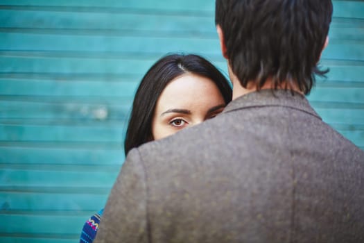 Young woman looking at camera out of man back