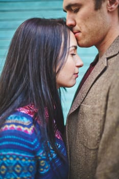 Amorous man kissing his girlfriend on forehead