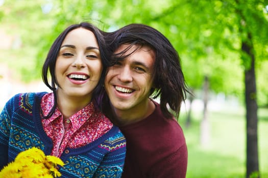 Ecstatic young couple looking at camera in park