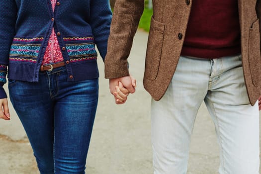 Young couple in casualwear holding by hands