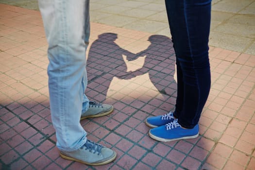 Young couple in jeans and sports shoes standing on trottoire