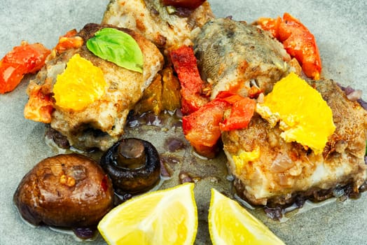 Diet fish hake cooked with mushrooms, orange and tomatoes.