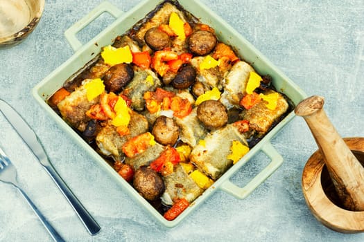 Diet fish hake cooked with mushrooms, orange and tomatoes.