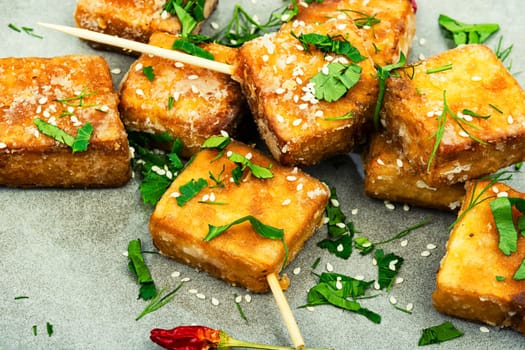 Skewers with roasted tofu cheese with and sesame seeds. Close up