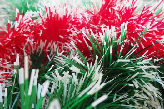 New Year and Christmas decorations, red and green boas for the Christmas tree. Two-color Christmas rain garlands are mixed. Festive decor