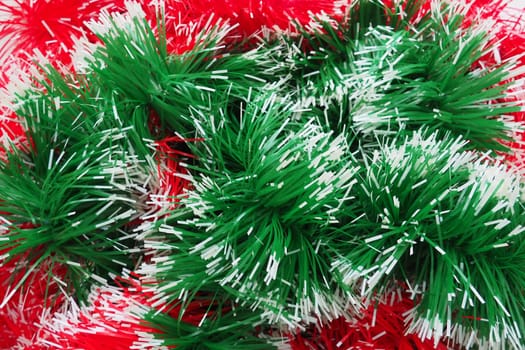 New Year and Christmas decorations, red and green boas for the Christmas tree. Two-color Christmas rain garlands are mixed. Festive decor