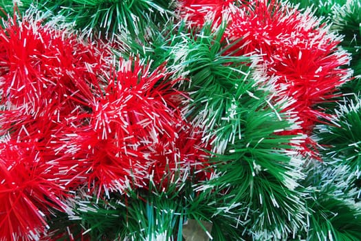 New Year and Christmas decorations, red and green boas for the Christmas tree. Two-color Christmas rain garlands are mixed. Festive decor