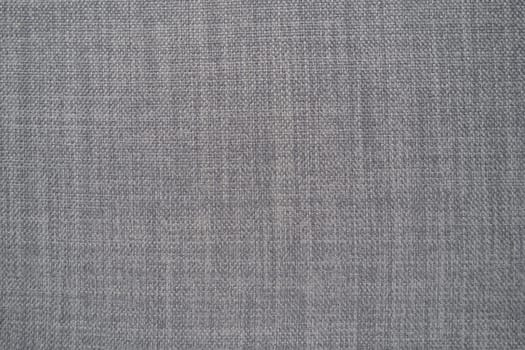 gray background fabric texture. A piece of woolen cloth is neatly laid out on the surface. Weave and textile texture. Dress fabric or for kitchen needs, tablecloth or curtains, close-up. Dash.
