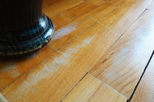 Scratched old parquet flooring needs maintenance. The parquet is damaged by scratches from prolonged use. The leg of an antique wooden bed scratched the floor.