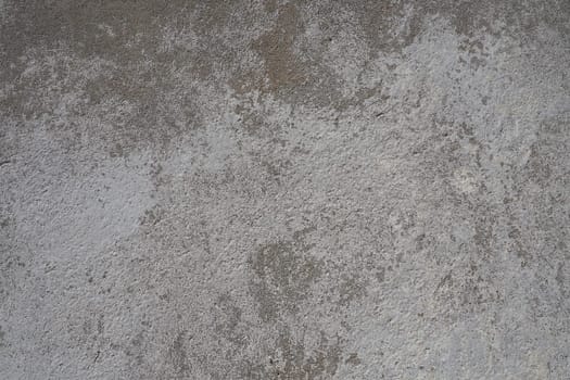 Plastered wall texture. Whitewash surface. Abstract background. Retro wall built structure texture. Cracks and bumps on the concrete wall. Uneven coloring with water-based paint. Old tattered plaster.