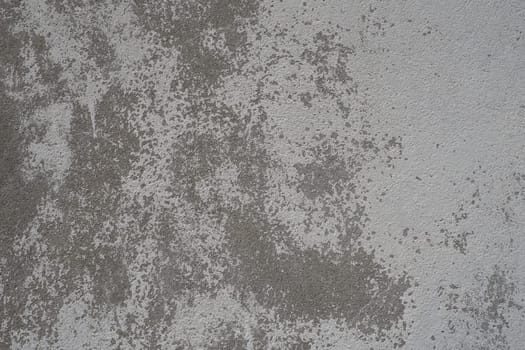 Plastered wall texture. Whitewash surface. Abstract background. Retro wall built structure texture. Cracks and bumps on the concrete wall. Uneven coloring with water-based paint. Old tattered plaster.