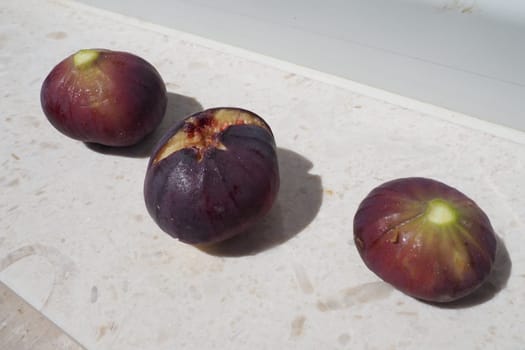 Fig or fig tree, or common fig tree, or Ficus carica is a subtropical deciduous plant of the genus Ficus of the Mulberry family. Ripe purple fig fruits on a light background. Healthy food.