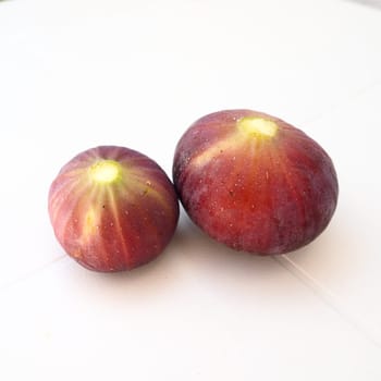Fig or fig tree, or common fig tree, or Ficus carica is a subtropical deciduous plant of the genus Ficus of the Mulberry family. Ripe purple fig fruits on a light background. Healthy food.