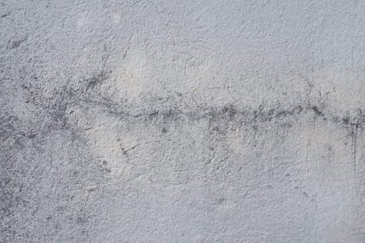 Plastered wall texture. Whitewash surface. Abstract background. Retro wall built structure texture. Cracks and bumps on the concrete wall. Uneven coloring with water-based paint. Old tattered plaster.