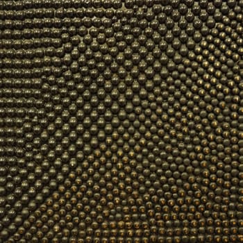 Pimples or spikes made of black and gold metal. Metal rounded bulges are located randomly. Unusual abstract background