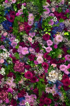 Lush floral display fills the backdrop with an exuberance of colors and textures, featuring diverse blooms and greenery, ideal for celebrations or decorative purposes.