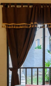 Glass window with brown velvet curtain