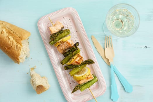 Grilled green asparagus skewers with salmon,baguette and lemon