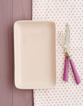 Small pink plate with pink cutlery on pink tray