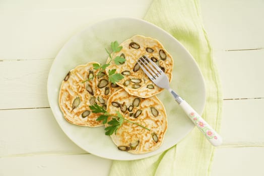 Pancakes with violet asparagus on a green plate