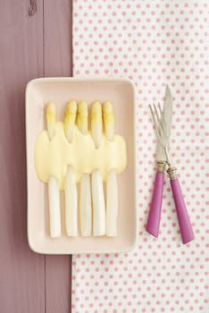 White asparagus with sauce Hollandaise on pink plates