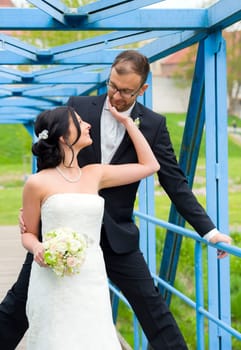 young bridal couple together in front of nature background