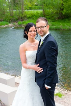 young bridal couple together in front of nature background