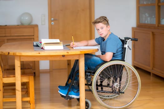 disabled boy in wheelchair doing homework