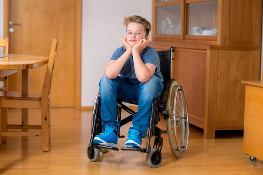 disabled boy in wheelchair at home in the living room