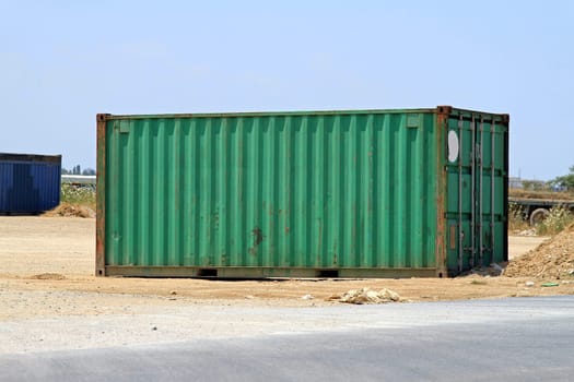 Green cargo shipping container in the field