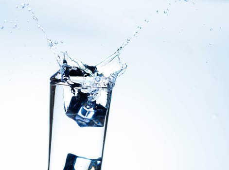 The image of pouring drinking water, into a glass, that makes one feel refreshed on blurred white background, Splashing water, Sparkling water