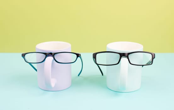 Cup or mug of coffee wearing eyeglasses, funny face, hot drink for breakfast, fathers day