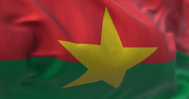 Close-up view of the Burkina Faso national flag waving in the wind. Burkina Faso is a country in West Africa. Fabric textured background. Selective focus. Realistic 3d illustration