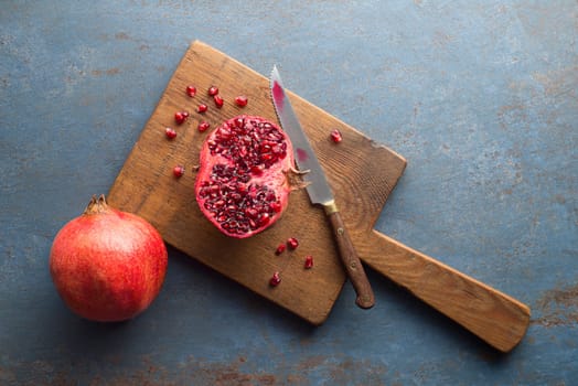 Healthy ripe pomegranate fruit opened and split with seeds on white plate