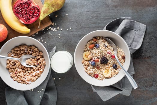 A bowl of muesli served with fresh fruit nuts and milk. Oatmeal plate. Healthy food, diet. Top view.