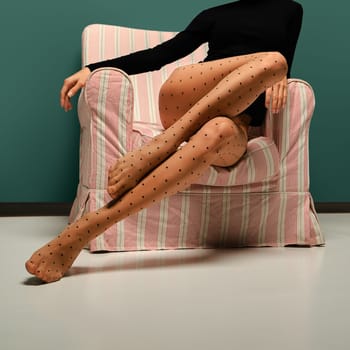 Slender female legs in tights with polka dot pattern