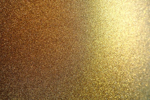 Gold close up. Golden glitter texture background. Sparkling glitter wrapping paper with sequins and sparkles. Festive golden bokeh and glitter. Beautiful background. Bokeh light of gold glitters.