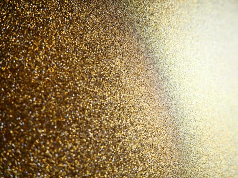 Gold close up. Golden glitter texture background. Sparkling glitter wrapping paper with sequins and sparkles. Festive golden bokeh and glitter. Beautiful background. Bokeh light of gold glitters.