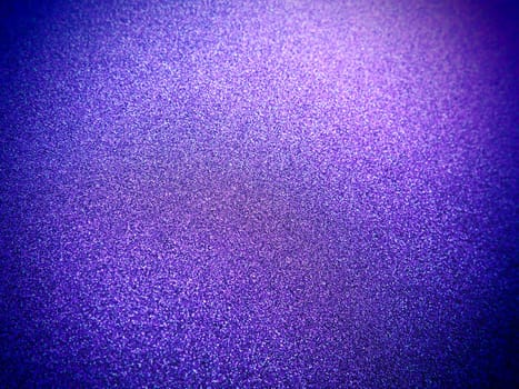 Deep blue. Texture of rough paper or cardboard. Defocused bokeh sparkles and shining. Festive blue background with illuminated sapphire gradient.