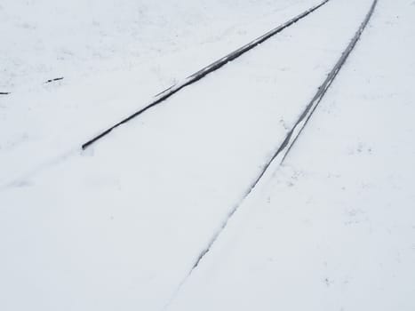 Railway in the snow. Rails covered by a snowstorm. Railway service, snow removal. Transport concept. Snowdrifts and drifts. Difficult weather conditions.