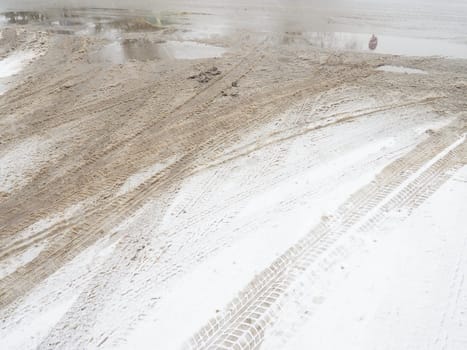 A fork or siding from a roundabout. Snowdrifts on the side of the road. Bad weather and traffic. Snow on asphalt. Difficult driving conditions. Winter slosh on the road. Braking distance of a car.