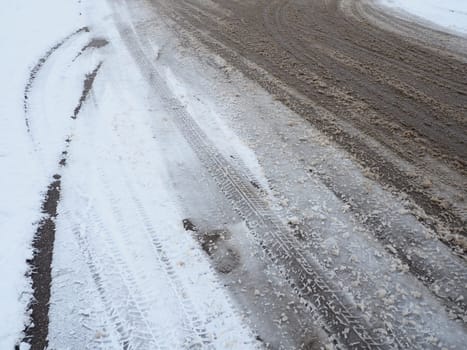 A fork or siding from a roundabout. Snowdrifts on the side of the road. Bad weather and traffic. Snow on asphalt. Difficult driving conditions. Winter slosh on the road. Braking distance of a car.