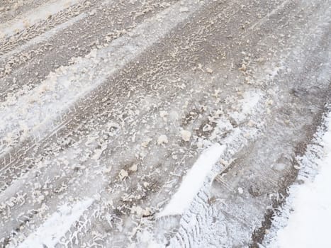 Snowdrifts on the side of the road. Bad weather and traffic. Snow on asphalt. Difficult driving conditions. Winter slosh on the road. Braking distance of a car