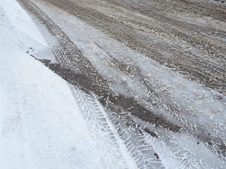A fork or siding from a roundabout. Snowdrifts on the side of the road. Bad weather and traffic. Snow on asphalt. Difficult driving conditions. Winter slosh on the road. Braking distance of a car.