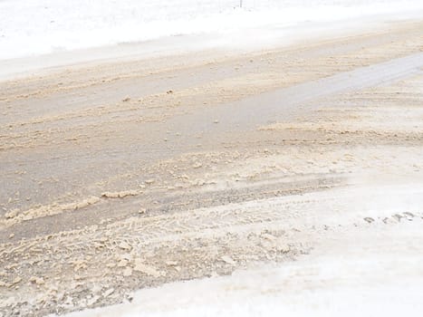 Snowdrifts on the side of the road. Bad weather and traffic. Snow on asphalt. Difficult driving conditions. Winter slosh on the road. Braking distance of a car