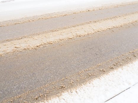 Snowdrifts on the side of the road. Bad weather and traffic. Snow on asphalt. Difficult driving conditions. Winter slosh on the road. Braking distance of a car